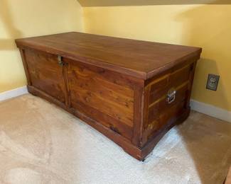 Vintage cedar chest with hinged lock and metal side handles, measures 52 1/2" wide x 24" deep x 21" high