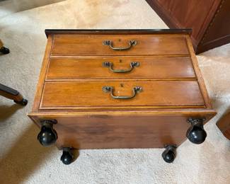 Bottom view of dark wood topped 3-drawer wood chest on wheels and side handles, measures 16" wide x 22" deep x 17" high