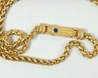 Detail of bar pendant with blue stone on gold Wheat Chain necklace with a bar pendant. Bar pendant has rhinestones and Lapis blue stone on one side.