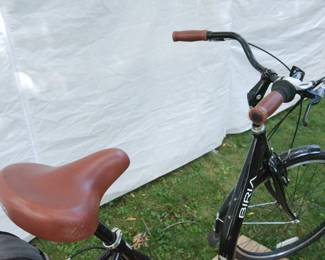 Seat and handlebar detail in brown leather of Black Biria Easy Boarding bicycle with luggage rack and bike bag, 46cm, designed in Germany