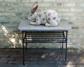 Large carved folk art wooden rabbit figurine, a white rabbit with red polkadots, shown on table for scale