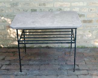 Outdoor table with stone top and wrought iron legs