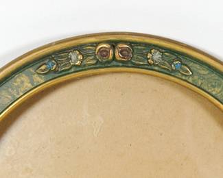 Detail of flowers on c. 1920s vintage picture frame green with gold trim and small flower details, rounded top