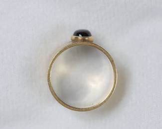 Side view of 14K yellow gold cigar band style ring with a black star sapphire, size 8 1/2