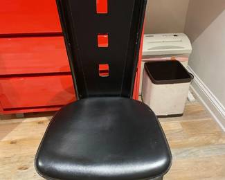 Black leather covers entire chair, including legs, with black stitching.