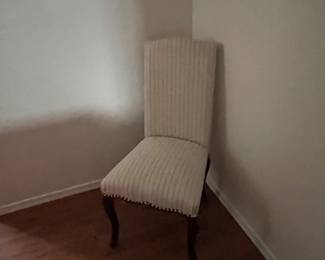 Upholstered side chair,  wood legs, fabric cream color with studs
