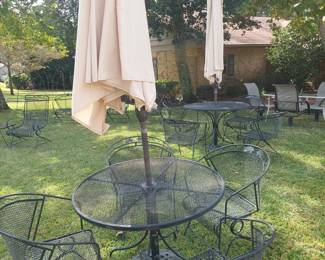 wrought iron round table with four chairs and umbrella