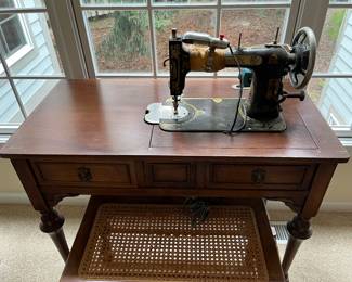 Domestic sewing machine on cabinet.