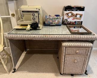 Wicker desk with pull-out, two-drawer cabinet.