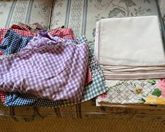 Vintage linens including aprons, tablecloth, and more.