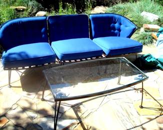 Mid-century wrought iron sofa and glass top coffee table.
