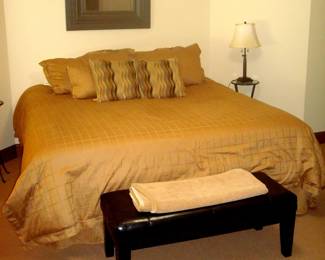 King bed and black leather bench.