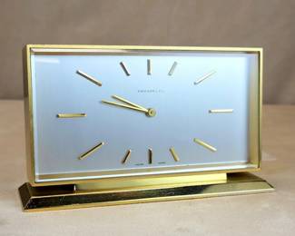 Streamline 1960s Tiffany & Co. Swiss Shelf Clock ImHof 8-day 15-jewel movement.   The substantial case is precisely machined and finished with grained matte and polished gold surfaces.  A thick beveled crystal covers the satin silvered dial with crisp raised baton markers.  Stick hands are easily "read" at a distance.

Imhof along with Swiss competitors Angelus, Looping and Luxor manufactured the best quality post WWII jeweled lever alarm, desk and shelf clocks.  The movement in this clock (produced exclusively for Tiffany & Co.) is the final iteration prior to quartz era timepieces eclipsing traditional mechanical works.        

The clock displays beautifully and holds accurate time, running a week on winding.  During July of 2023 the movement was completely disassembled (including removal of mainspring from barrel), ultrasonically cleaned and rinsed, elements checked for wear, reassembled and lubricated with high-grade Swiss grease and two viscosity oils.  The case, glass and dial w