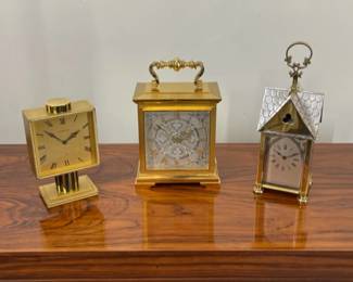 Three exceptionally fine and rare 8-day jeweled lever escapement shelf/table clocks. Handsome mid-century modern LeCoultre brass columnar timepiece.  Elegant gilded and silvered oversize striking carriage clock by Luxor.  Ca. 1890 gong-striking French Gothic Revival carriage clock  with partial nickel plated case.