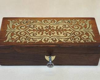 Napoleon III Writing Box - brass inlaid rosewood, silk damask lined with dip pen and inkpot.  A handsome and exceptionally fine mid-19th century writing box displaying premier workmanship.  $235

Benchcrafted of exotic rosewood veneer with elaborately cut brass decorative inlay and shield escutcheon plate.  Handmade self-stopping hinges.  Functional lock with key.  Interior of cover upholstered with silk floral damask.  Box with divided compartments of red lacquered wood.  Silk covered lids for wells (with red sealing wax) flanking a blown glass inkwell with domed silver top.  Narrow rear and front slots designed for 6" dip / quill (or calligraphy) pens.  

This rare box is in fine original condition, absent significant damage.  2 1/8" high, 7 3/8" wide, 3 1/4" deep