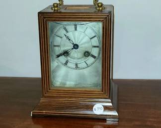 Louis-Philippe "Officer's Clock."  Boxwood banded rosewood case with gilt-bronze handle.  Engine turned and silvered dial painted with Roman numerals.  Elaborate pierced steel hands.  8-day bell striking movement with silk suspension.  Original throughout - not restored.  Case excellent.  Movement complete and functional with period key.  Sliding front panel glass broken.  Easily replaced.  9" high to top of handle, 6.25" wide, 5" deep.        $395
