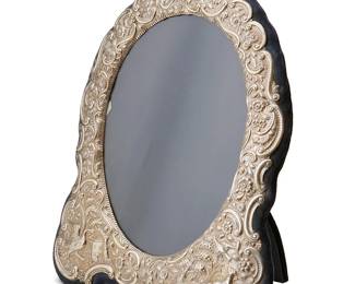 1053
1894
An English Sterling Silver Overlay Picture Frame
With English hallmarks for London
The repoussé silver overlay with animals and a cottage over blue velvet surrounding an oval opening
23" H x 18" W; opening: 15" H x 11.5" W
Estimate: $500 - $700