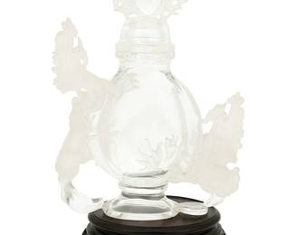 1064
20th century
A Carved Rock Crystal Cabinet Bottle With Dragons
Marked with an etched diamond to the underside of the base
Possibly Chinese, the footed vessel with opposing, finely carved dragons to each side, each with a frosted finish, and a flaming pearl finial; set upon a carved wood stand, 2 pieces
With stand: 10" H x 6" W x 3" D
Estimate: $2,000 - $3,000