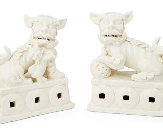 1078
Republic Period 1912-1949 or later
A Pair Of Chinese Dehua-Style Porcelain Guardian Lions
Each appears unmarked
Two glossy white ceramic lion figures, one male with embroidered ball under paw and one female with a cub alongside, each on a pedestal with wrap-around medallion motif, 2 pieces
Each: 7.25" H x 5.25" W x 3" D
Estimate: $500 - $700
