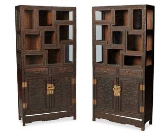 1079
20th century
A Pair Of Japanese Step Curio Cabinets
Each appears unmarked
The ebonized wood cabinets with allover carved wood lotus scroll motifs and brass hardware, the upper half featuring variously shaped rectangular display compartments with plate glass doors and side panels, the lower half featuring two drawers above two large cabinets with locking mechanisms, 2 pieces
Each: 74.5" H x 36" W x 14.75" D
Estimate: $6,000 - $8,000