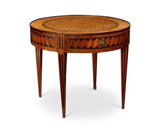 1238
Early 20th century
A Louis XVI-Style Inlaid Wood Game Table
Appears unmarked
The round gaming table with parquetry inlay of mahogany and satin wood veneers in repeating geometric motifs, two opposing drawers with cast brass pulls, and two slide out gaming surfaces with inset leather tops to either side; set upon four spade-shaped legs, each with a brass endcap
30" H x 35.5" Dia.
Estimate: $500 - $700