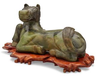 1276
20th century
A Carved Semiprecious Stone Horse
Appears unmarked
The equine carved from a dark green stone with mottled yellow and brown inclusions, likely nephrite, set on a carved wood stand, 2 pieces
With stand: 12.5" H x 23" W x 10.5" D
Estimate: $600 - $800