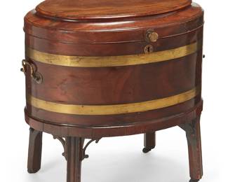 1283
Late 19th/early 20th century
A George III Brass-Bound Mahogany Wine Cooler
Appears unmarked
The oval-shaped beverage cooler with inlaid brass banding and opposing cast brass handles to either side, a hinged, locking lid, and set upon four squared legs, each with a brass casters
22" H x 21.5" W x 16.5" D
Estimate: $500 - $700