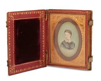 1284
Early/mid-19th century
A Traveling Portrait Case
The case in the form of a book with gilt-stamped leather spine, gilt edges, brass latches, and front and rear panels with mother-of-pearl and abalone inlay, the front panel with a raised relief carved mother-of-pearl profile bust of a woman; the interior revealing a diminutive portrait of a woman set in a gold-toned frame with protective velvet cushion to verso of front panel
5" H x 4.25" W x 1.125" D
Estimate: $400 - $600