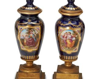 1349
Late 19th/early 20th century
A Pair Of Diminutive Sèvres-Style Porcelain Urns
Each appears unmarked
Two porcelain lidded vessels, each centering a painted reserve depicting a mother and child surrounded by cobalt glaze and gilt ornamentation; each set upon a gilt bronze pedestal, 2 pieces
Each: 6.5" H x 2" W x 2" D
Estimate: $600 - $800