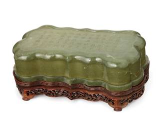 1372
Late Qing Dynasty 1636-1912 or later
A Chinese Carved Nephrite Box
With inscribed poem to the top in Chinese characters and seals for the author: Qian Long
An irregularly shaped, thin-walled rectangular box carved from nephrite and incised on the top to display an imperial poem; along with a carved wood stand
Overall: 3" H x 8" L x 4.5" D
Estimate: $1,000 - $1,500