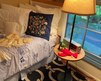 Twin cane headboard, table lamp, pillows and area rug