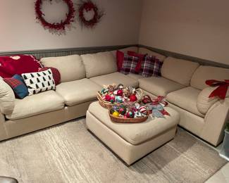Ivory sectional with ottoman, holiday pillows and ornaments