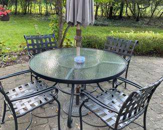 Glass-topped 48" patio table with 4 chairs, umbrella and stand