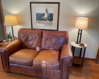 Leather loveseat, side tables and iron lamps