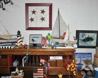 Oak rolltop desk, collection of lighthouse items, ship decor, oak two-drawer file cabinet,  lots of red/white/blue decor, stack of nesting round baskets, blue pails.