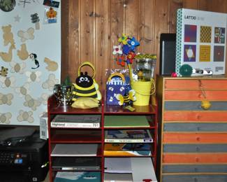 This room is enormous!  This half is filled with children's books, games and puzzles, office supplies, tole painting supplies, Ikea storage containers, craft supplies, dressers, tall multi-drawer cabinet, printer, craft kits, boxes, frames, antique children's desks, red/white/blue decorations, bee collectibles, pails, rocking horses, children's furniture, dining chairs, stuffed animals, baskets, and sooo much more!