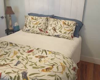 Custom-made queen size bed crafted by the homeowners,  vintage Lumber and wrought iron porch rail.