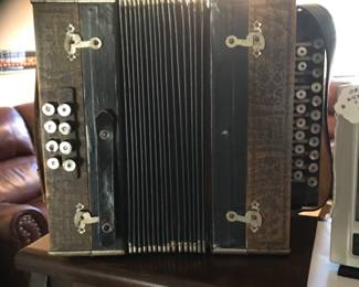 This a beautiful antique accordion with pearl buttons.