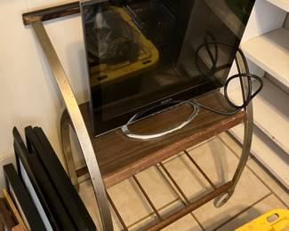 Mid century TV stand and computer monitor.  Also lots of frames. 