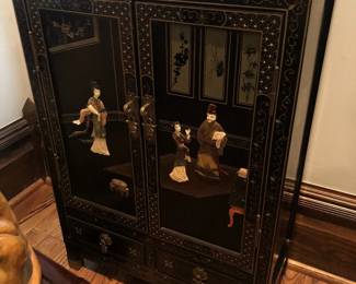 A vintage Chinoiserie black lacquer cabinet with carved hardstone decoration.