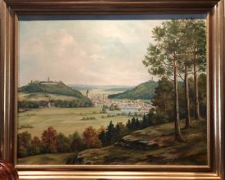 Original autumn landscape painting depicting pine-covered hills overlooking a town with red-roofed buildings, artist signed.