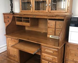 Vintage traditional oak roll top desk with slide-out keyboard table and fitted compartments.