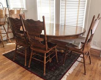 Vintage pressed oak extendable dining table with four side chairs and matching counter stools.