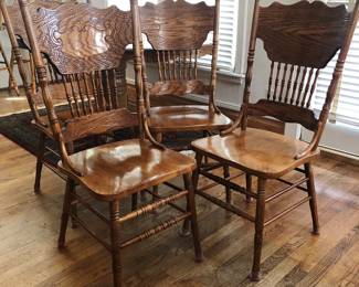 Vintage pressed oak extendable dining table with four side chairs and matching counter stools.
