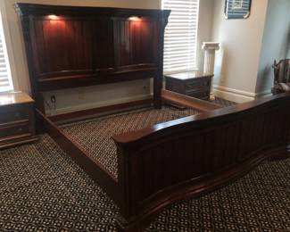 King-size dark-stained hardwood bed with lighted headboard.