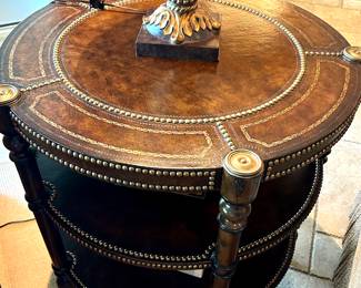 Leather top round transitional center table. Brass accents. 32” tall, 32” diameter