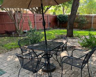 Prettier patio table and four chairs along with an umbrella