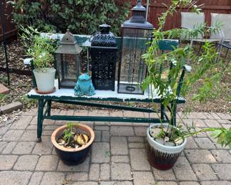 Lots of Lanterns sitting on a vintage bench and nice planters