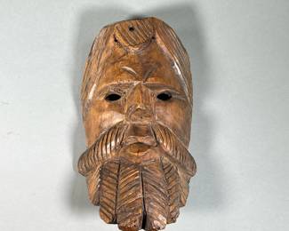 HAND-CARVED GUATEMALAN MASK | Hand-carved wooden mask in the shape of a serious man with a large coiled beard. - l. 6 x w. 4 x h. 12 in