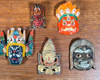 (5PC) SMALL COLORFUL MASKS LOT | Includes four hand carved wooden masks and one Mongolian ceramic mask of various styles and origins. - l. 6 x w. 2 x h. 6.5 in